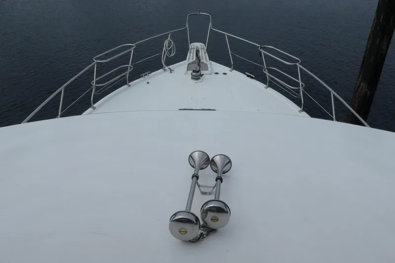 Slide: The Image of Bow view of 1989 Angel Pilothouse yacht with railings and horn, on calm water. - 48