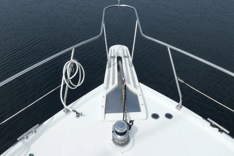 Slide: The Image of Bow view of 1989 Angel Pilothouse boat with anchor chain and calm water. - 49