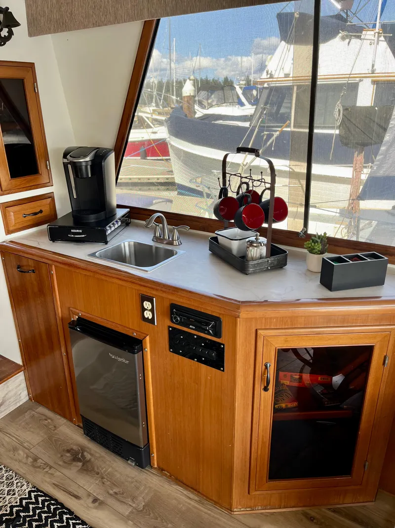Slide: The Image of 1989 Angel Pilothouse kitchen with sink, coffee maker, and marina view. - 6