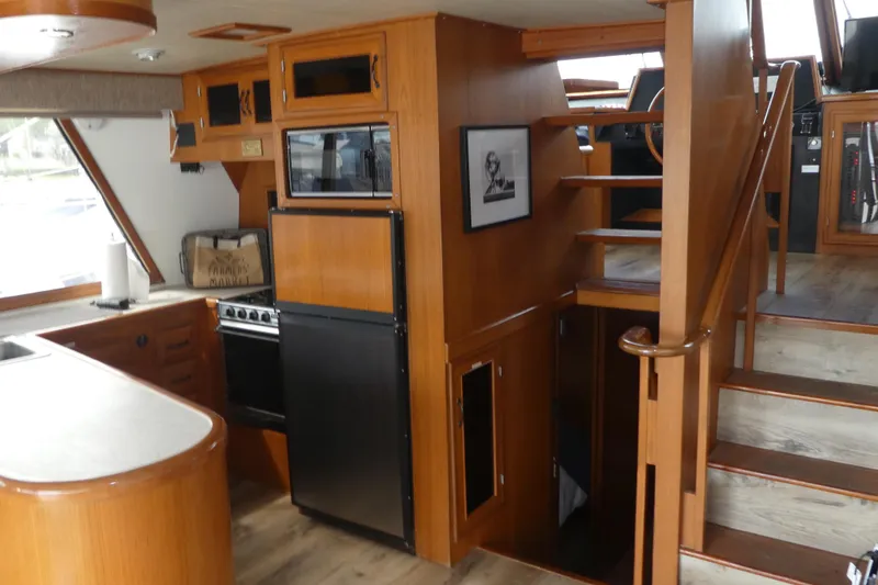 Slide: The Image of 1989 Angel Pilothouse interior with wooden cabinetry, stairs, and kitchen area. - 9