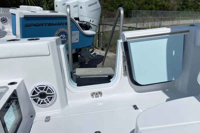 Slide: The Image of 2026 Sportsman Heritage 321 Center Console boat with open side door and visible Mercury engines. - 15