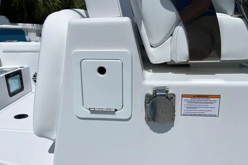 Slide: The Image of 2026 Sportsman Heritage 321 Center Console boat detail with storage compartment and warning label. - 26
