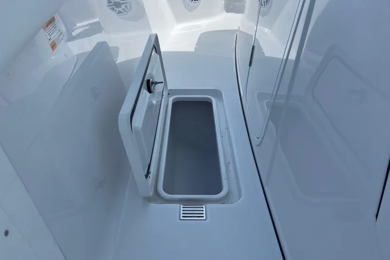 Slide: The Image of 2026 Sportsman Heritage 321 Center Console storage compartment, open and empty, showcasing sleek design. - 36