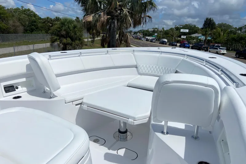 Slide: The Image of 2026 Sportsman Heritage 321 Center Console boat with white seating and table, parked near palm trees. - 41