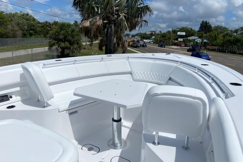 Slide: The Image of 2026 Sportsman Heritage 321 Center Console boat with white seating and table, palm trees in background. - 42