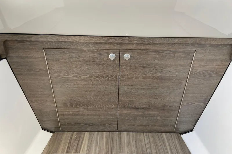 Slide: The Image of Wooden cabinet doors inside 2026 Sportsman Heritage 321 Center Console boat. - 54