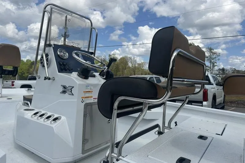 Slide: The Image of 2025 Xpress H20B Bay boat console and seating under a cloudy sky. - 19