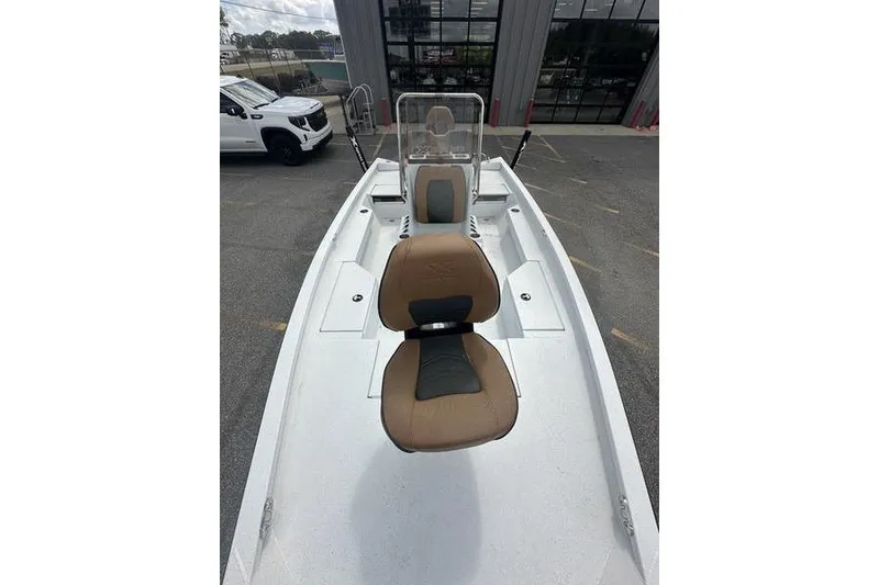 Slide: The Image of 2025 Xpress H20B Bay boat with tan seating, parked outdoors. - 5