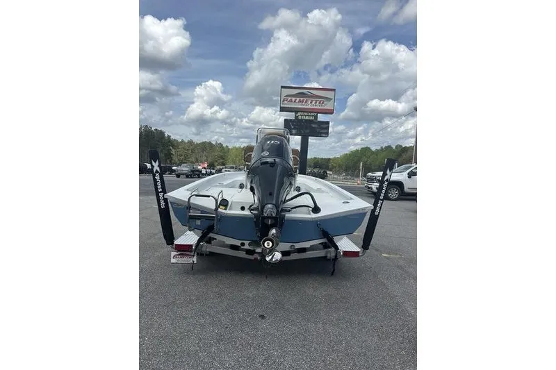 Slide: The Image of 2025 Xpress H20B Bay boat on trailer, parked outdoors under cloudy sky. - 6
