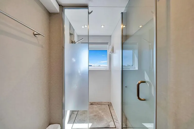 Slide: The Image of Modern shower area with glass doors and a window view on a 2020 Hargrave C92 yacht. - 124