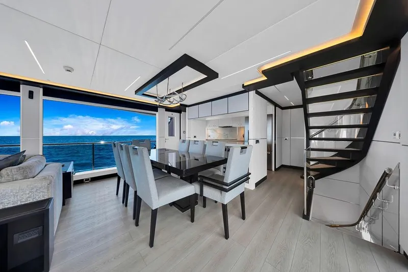 Slide: The Image of Luxurious interior of 2020 Hargrave C92 yacht with ocean view, modern dining area, and staircase. - 70