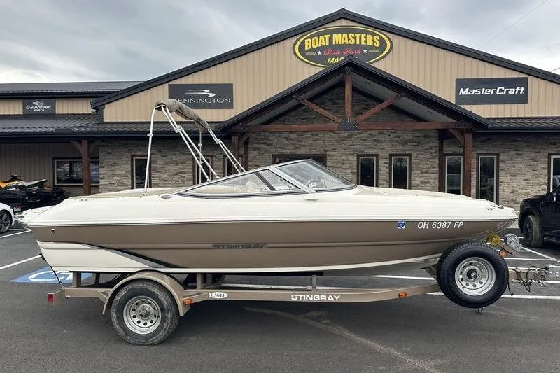 The Image of 2015 Stingray 208 LR boat on trailer outside dealership, Boat Masters sign visible. - 1