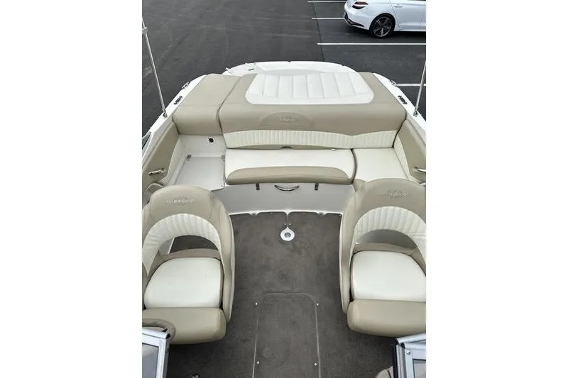 Slide: The Image of 2015 Stingray 208 LR boat interior with beige and white seating. - 14