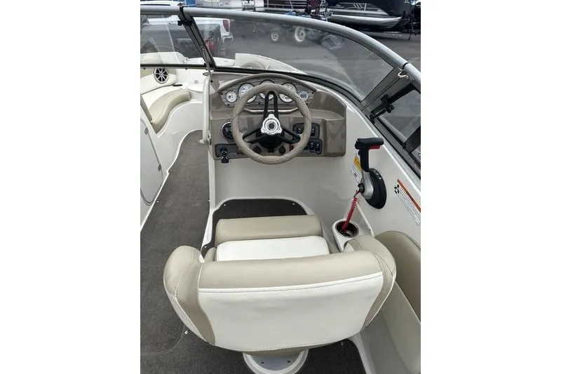 Slide: The Image of 2015 Stingray 208 LR boat interior with steering wheel and beige seating. - 18