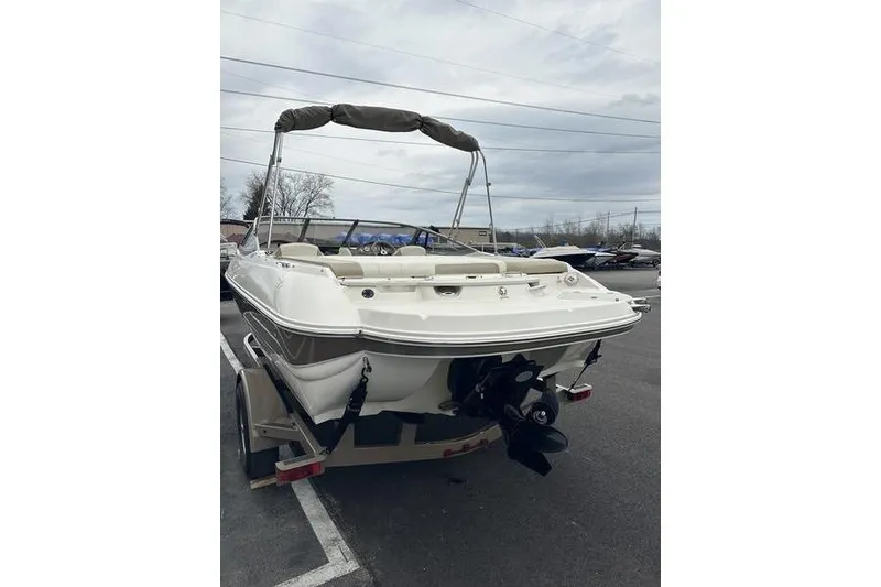 Slide: The Image of 2015 Stingray 208 LR boat with bimini top, parked on a trailer. - 4
