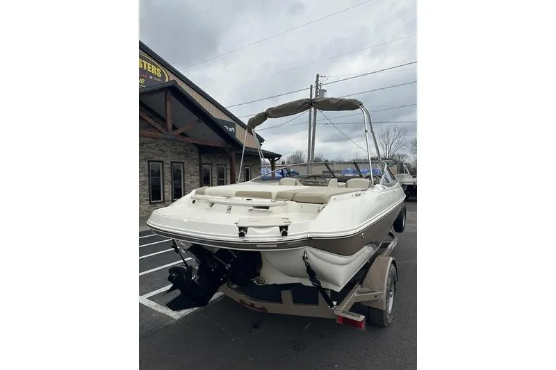 Slide: The Image of 2015 Stingray 208 LR boat on trailer, parked outside a building. - 5