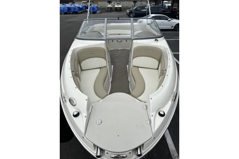 Slide: The Image of 2015 Stingray 208 LR boat with beige and white seating, parked in a lot. - 8