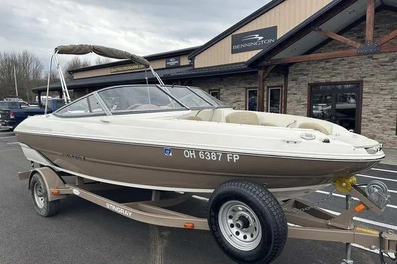 Slide: The Image of 2015 Stingray 208 LR boat on trailer, parked outside Bennington building. - 9