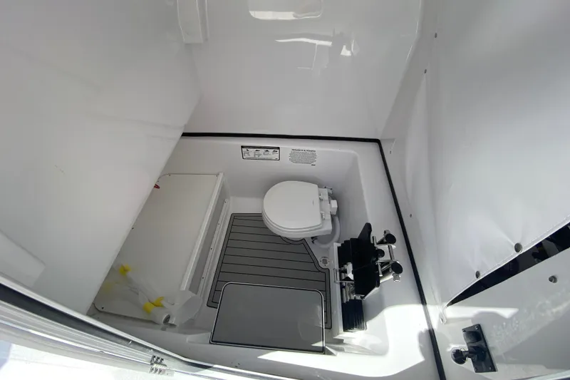 Slide: The Image of 2026 Sportsman Open 282 Center Console boat interior with compact marine toilet. - 22