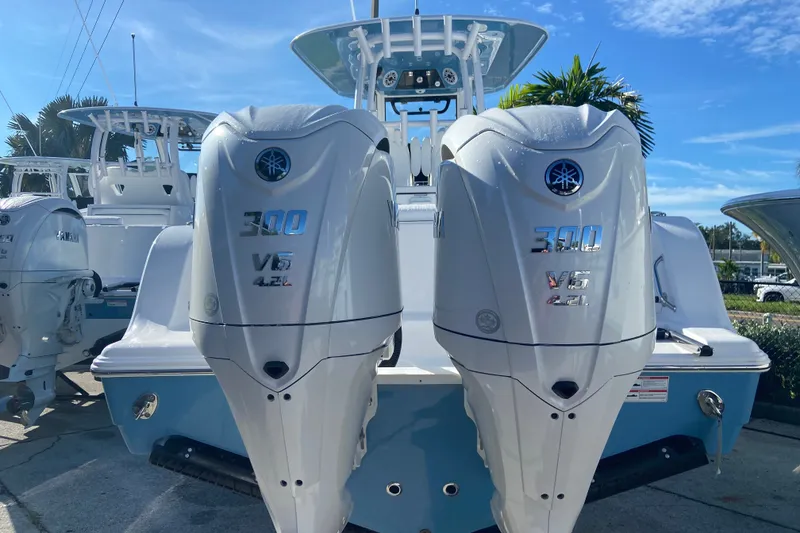 Slide: The Image of 2026 Sportsman Open 282 Center Console with twin 300 V6 engines, docked outdoors. - 2