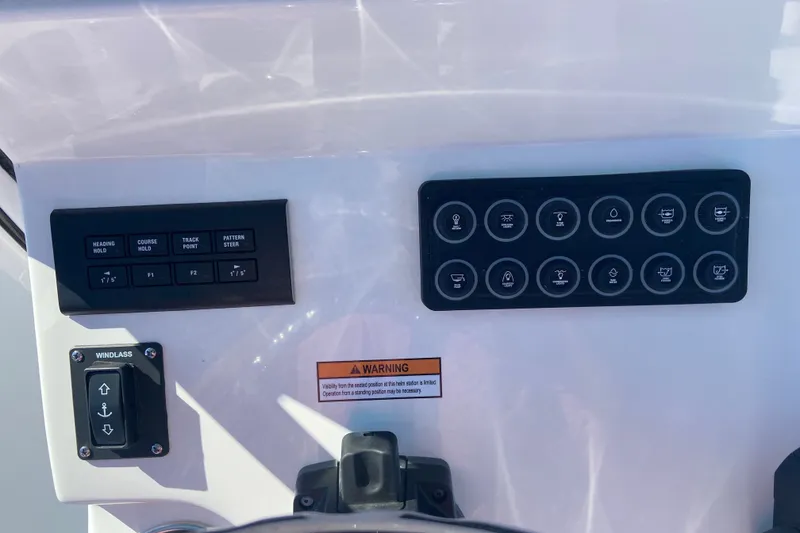 Slide: The Image of 2026 Sportsman Open 282 Center Console dashboard with control buttons and warning label. - 12