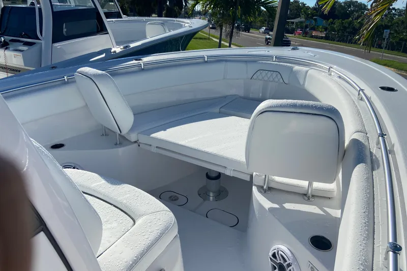 Slide: The Image of 2026 Sportsman Open 282 Center Console boat interior with seating and table, under sunny skies. - 15