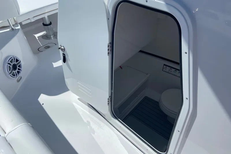 Slide: The Image of 2026 Sportsman Open 282 Center Console boat interior with open door and visible toilet. - 21
