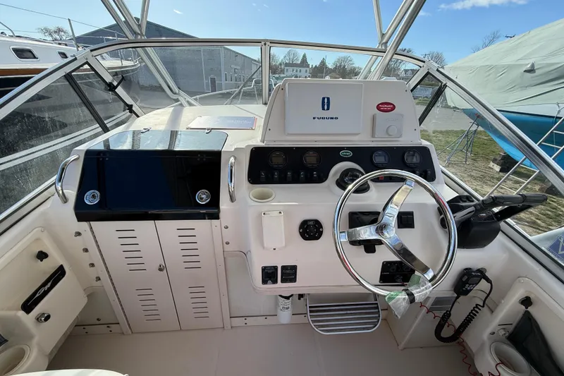 Slide: The Image of 2005 Grady-White Sailfish 282 boat helm with steering wheel and navigation controls. - 10