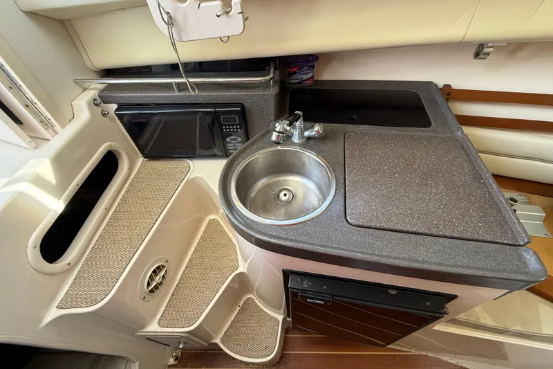 Slide: The Image of 2005 Grady-White Sailfish 282 boat interior with kitchenette, sink, and microwave. - 12