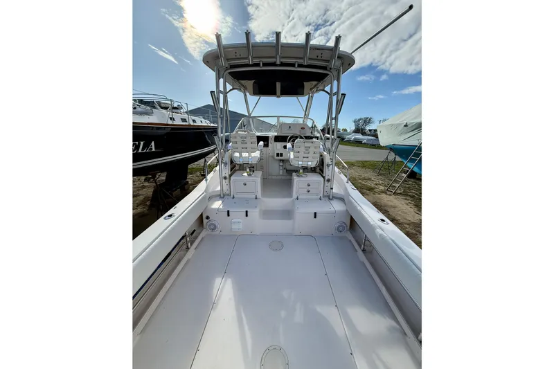 Slide: The Image of 2005 Grady-White Sailfish 282 boat interior with seating and helm, under a partly cloudy sky. - 7