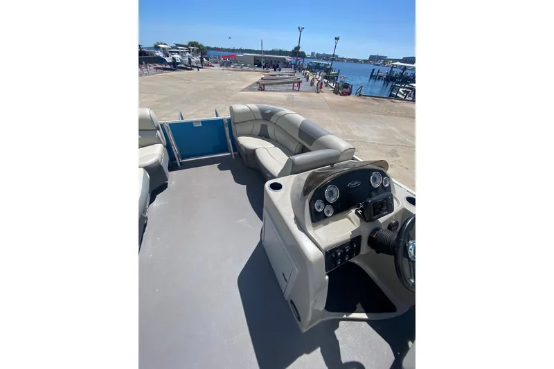 Slide: The Image of 2020 Star Craft 20 DLX boat interior with seating and control panel at a marina. - 5