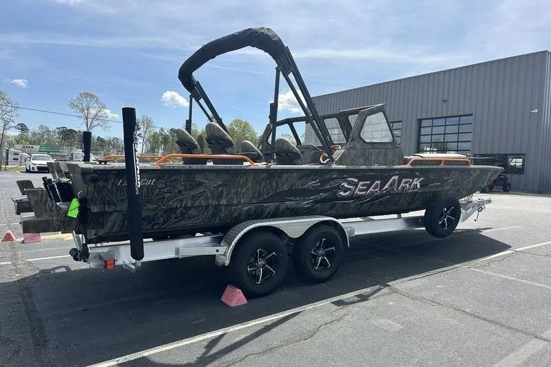 Slide: The Image of 2026 SeaArk EasyCat boat on trailer, parked outside a building. - 11