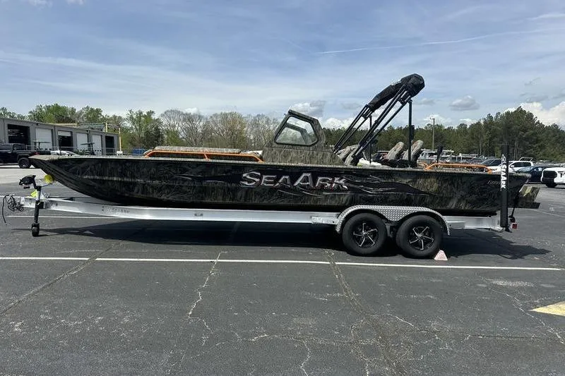 Slide: The Image of 2026 SeaArk EasyCat boat on trailer in parking lot, side view. - 12