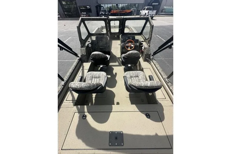 Slide: The Image of 2026 SeaArk EasyCat boat interior with four seats and steering wheel, parked outdoors. - 14