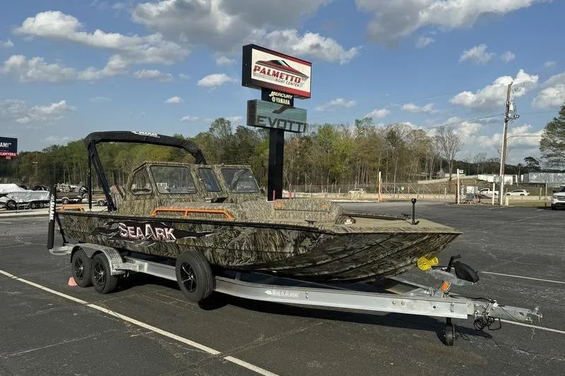 Slide: The Image of 2026 SeaArk EasyCat boat on trailer at dealership, under clear sky. - 17