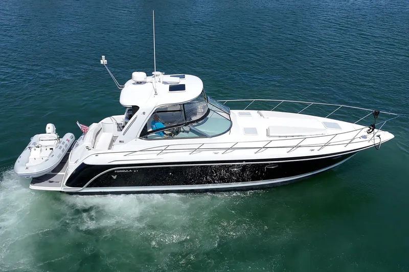 Slide: The Image of 2005 Formula 40 Performance Cruiser on water, sleek design, white and black exterior. - 12