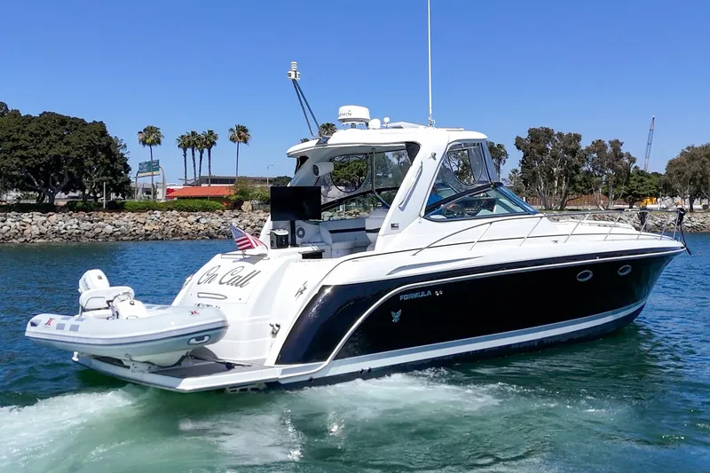 Slide: The Image of 2005 Formula 40 Performance Cruiser yacht on water, sunny day, palm trees in background. - 7