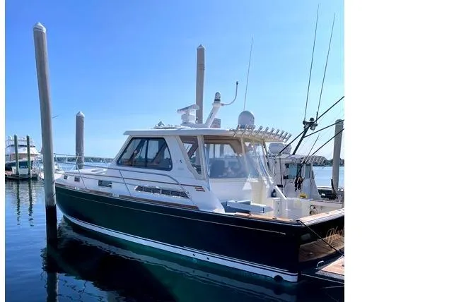 Slide: The Image of 2006 Sabre 38 Hard Top Express boat docked in sunny marina. - 2