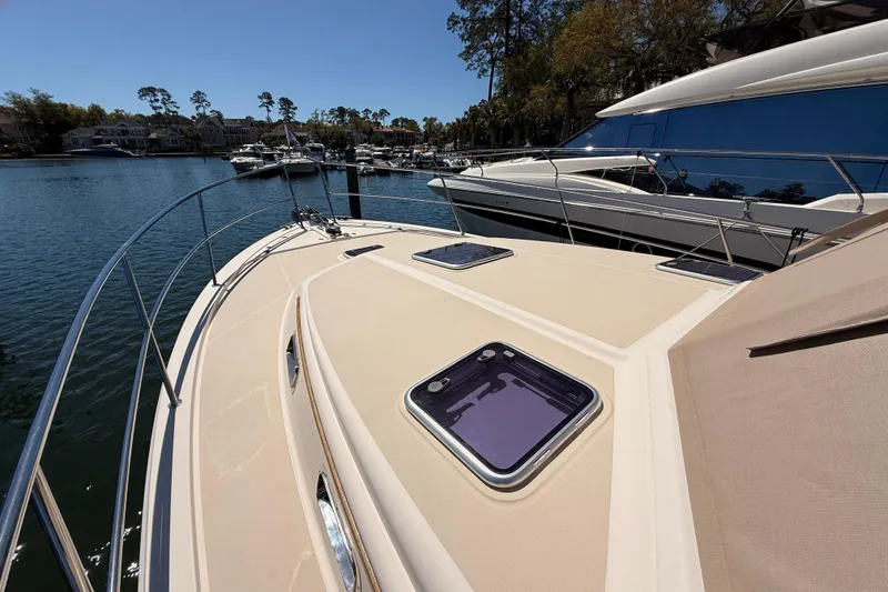 Slide: The Image of 2022 Sabre 38 Salon Express yacht docked in a serene marina setting. - 11