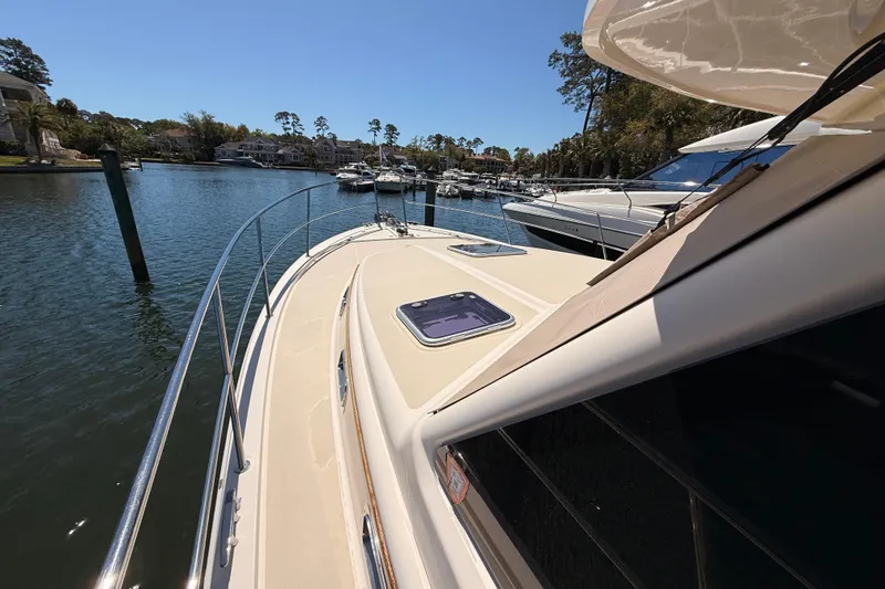 Slide: The Image of 2022 Sabre 38 Salon Express yacht docked in a serene marina setting. - 12