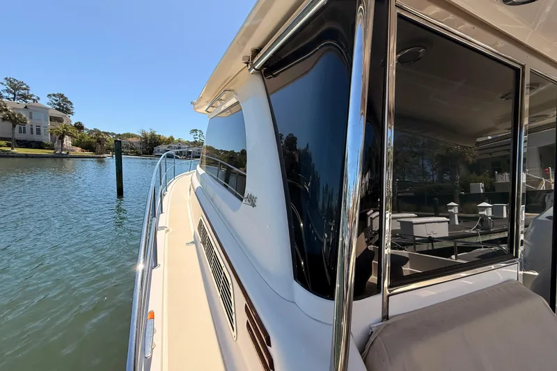 Slide: The Image of 2022 Sabre 38 Salon Express yacht docked by waterfront homes. - 14