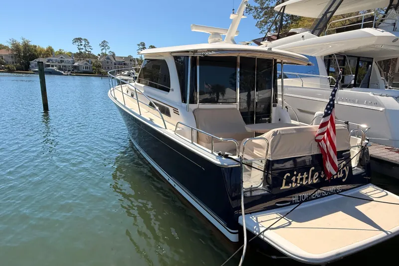 Slide: The Image of 2022 Sabre 38 Salon Express yacht docked, featuring sleek design and American flag. - 2