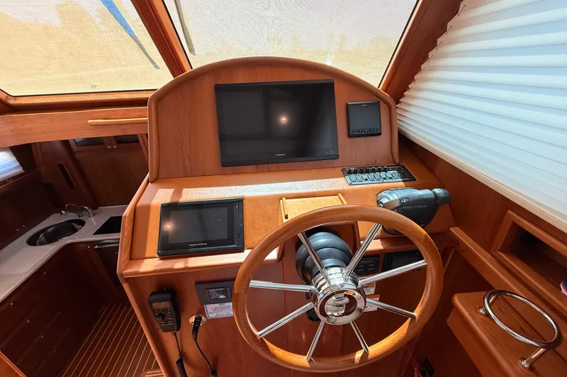 Slide: The Image of Helm of 2022 Sabre 38 Salon Express with modern navigation equipment and wooden finish. - 24