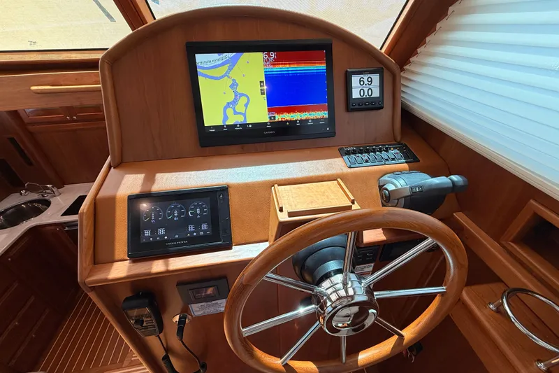 Slide: The Image of Helm of 2022 Sabre 38 Salon Express with navigation screens and wooden steering wheel. - 25