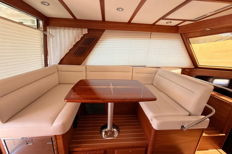 Slide: The Image of Interior of 2022 Sabre 38 Salon Express with elegant seating and wooden table. - 30