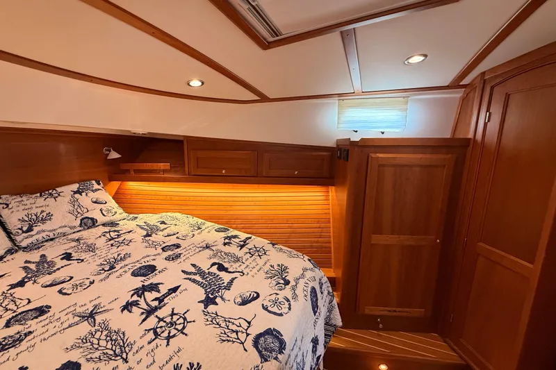 Slide: The Image of Luxurious 2022 Sabre 38 Salon Express cabin with nautical-themed bedding and elegant wood finishes. - 45