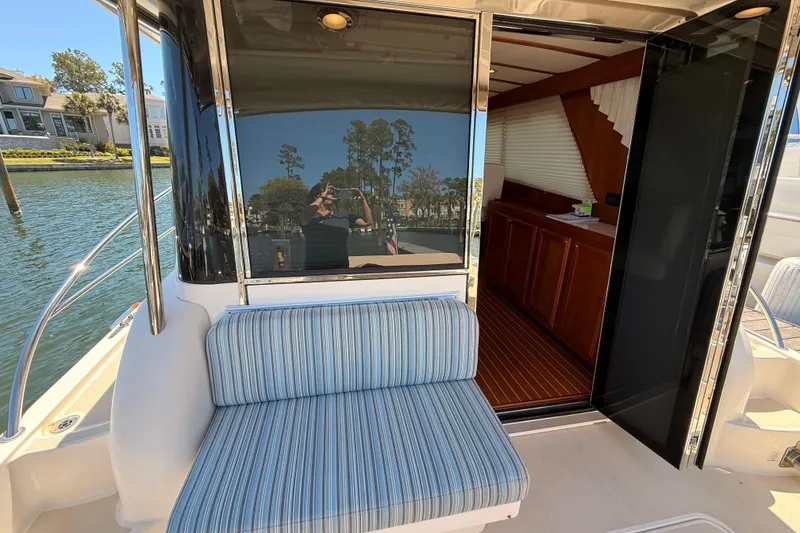 Slide: The Image of 2022 Sabre 38 Salon Express yacht with striped seating and open cabin door. - 50