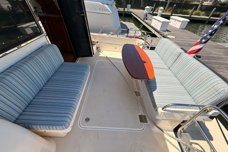Slide: The Image of 2022 Sabre 38 Salon Express yacht deck with striped seating and wooden table. - 51