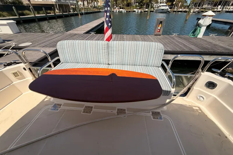 Slide: The Image of 2022 Sabre 38 Salon Express yacht with cushioned seating and wooden table on deck. - 52