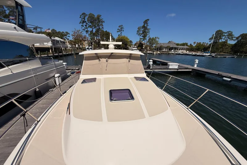 Slide: The Image of 2022 Sabre 38 Salon Express yacht docked at marina under clear blue sky. - 6